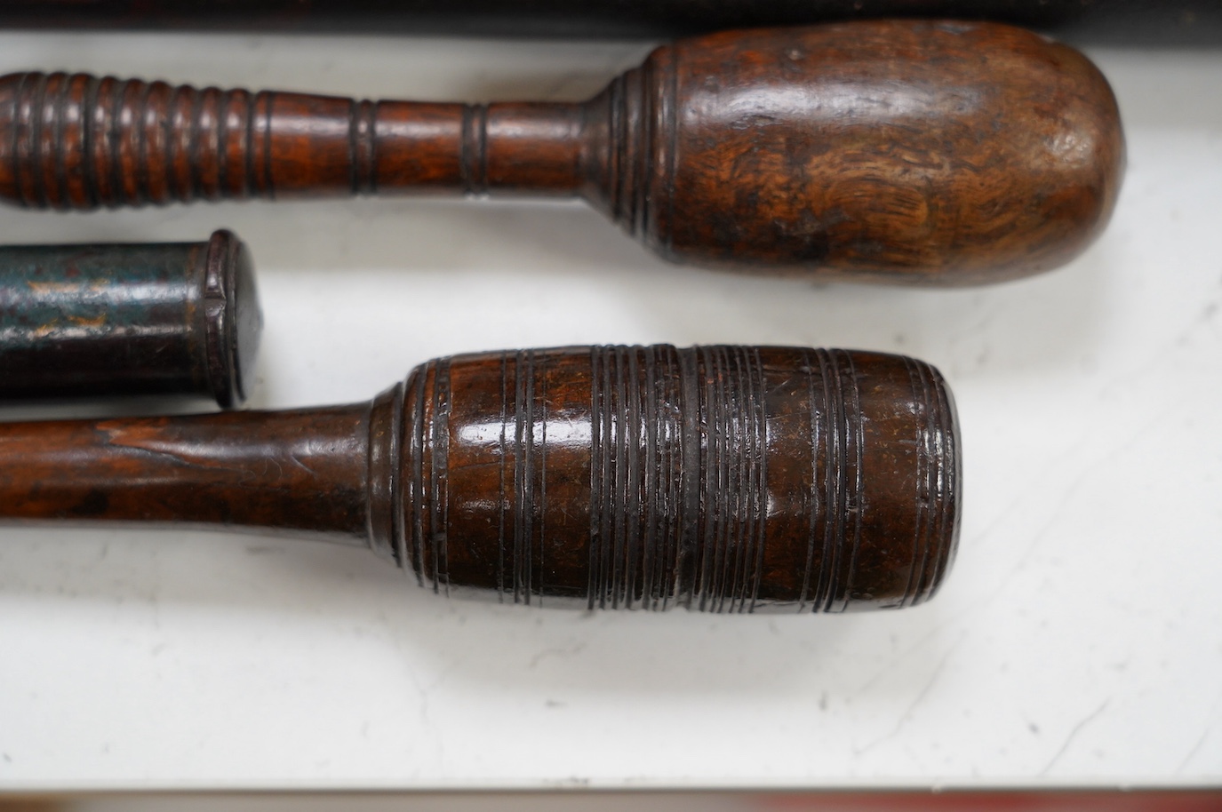 A large fruitwood gavel, a truncheon, a lead-weighted cosh and two others, longest 42cm. Condition - fair